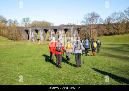 Groupe de randonneurs marchant dans la campagne du Cheshire approchant du viaduc ferroviaire sur la rivière Dean près de Wilmslow Cheshire Banque D'Images