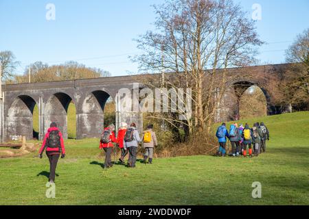 Groupe de randonneurs marchant dans la campagne du Cheshire approchant du viaduc ferroviaire sur la rivière Dean près de Wilmslow Cheshire Banque D'Images