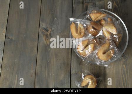 Rayonnement des fêtes chinoises. Biscuits de fortune couchés dans un bol sur un fond gris d'espace de copie. Banque D'Images
