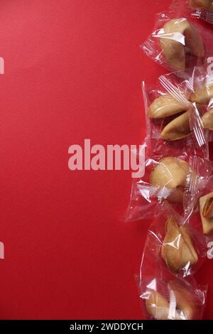 Cadre de biscuits de fortune savoureux avec des prédictions sur fond rouge, plat. Espace pour le texte. Banque D'Images