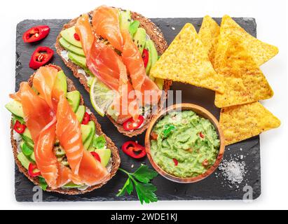 Toasts de saumon - pain avec tranches de saumon et tartinade d'avocat, guacamole et chips de tortilla. Vue de dessus. Banque D'Images