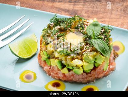 Tartare de saumon sur plaque bleue en gros plan. Banque D'Images