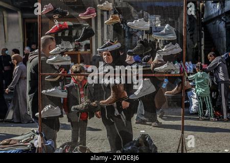 Rafah, Territoires palestiniens. 20 janvier 2024. Les Palestiniens regardent les stands de chaussures dans la rue de Rafah. L’UNRWA a déclaré que la population de la ville de Rafah a presque quadruplé pour atteindre plus de 1,300 millions de personnes, alors que les Palestiniens déplacés de Jabalia, Sheikh Zayed, Al-Wusta, Khan Yunis et Gaza City, fuient les combats sanglants entre Israël et le Hamas. Crédit : Abed Rahim Khatib/dpa/Alamy Live News Banque D'Images