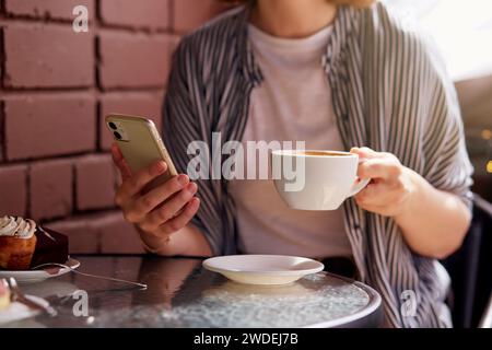 Femme pendant une pause café savourant un moment de sa journée bien remplie. Vie urbaine, vie urbaine. Banque D'Images