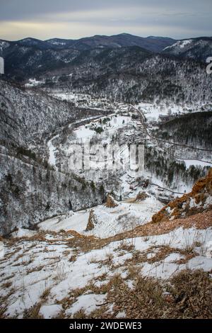 Vue de la colline aux cottages de campagne. Paysage hivernal à la périphérie de la ville de Krasnoyarsk, crête Torgashinsky. Randonnée à proximité de la civilisation. Banque D'Images