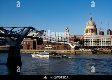 Uber Boat passe sous le Millennium Bridge sur la Tamise à côté de la cathédrale St Pauls de Bankside le 16 janvier 2024 à Londres, Royaume-Uni. St Pauls Cathedral est une cathédrale anglicane de Londres. En tant que siège de l'évêque de Londres, la cathédrale sert d'église mère du diocèse de Londres. Il se trouve sur Ludgate Hill au point culminant de la City de Londres et est un bâtiment classé Grade I. Banque D'Images