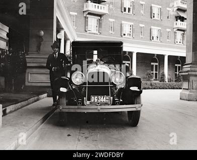 Rudolph Valentino 1923 debout près d'une belle voiture de collection à l'entrée de l'hôtel Banque D'Images