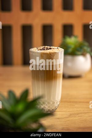 Verre avec délicieux latte macchiato chaud, café en couches dans une tasse à café en verre transparent. Banque D'Images