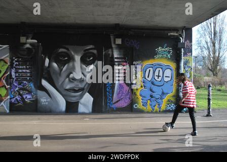 Piéger un ballon de football devant un mur d'art Shoreditch. Banque D'Images