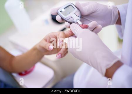 Docteur en culture vérifiant le taux de sucre du patient en clinique Banque D'Images