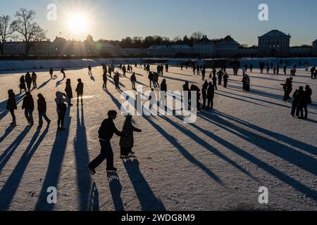 Wintervergnügen auf dem zugefrorenen Nymphenburger Kanal, München, Januar 2024 Deutschland, München, Januar 2024, Wintervergnügen am Nymphenburger Schlosskanal, Eislaufen und Spazierengehen, viele Münchner bummeln am Samstagnachmittag BEI Minusgraden über den zugefrorenen Kanal oder laufen Schlittschuh, die tiefstehende Wintersonne wirft lange Schatten und taucht -8 die Szene in ein warmes Gegenlicht Eisfläche, Graaturd tragfähig Winter, Wochenende, Bayern, *** Winter Fun on the Frozen Nymphenburg Canal, Munich, Banque D'Images