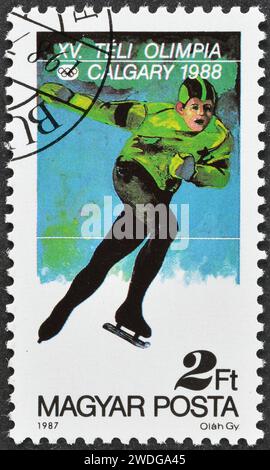 Timbre-poste annulé imprimé par la Hongrie, qui montre le patinage de vitesse, la promotion des Jeux olympiques d'hiver à Calgary, vers 1987. Banque D'Images