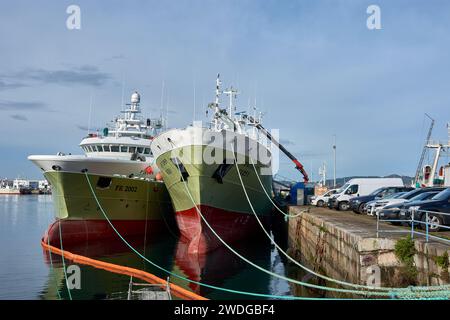 VIGO, ESPAGNE-19 décembre 2021 : bateaux de pêche verts amarrés avec des cordes dans le port de Vigo chargeant du matériel pour retourner à la mer Banque D'Images