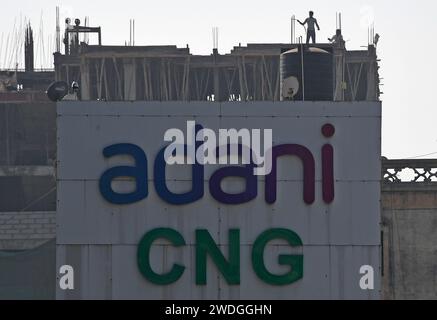 Le logo Adani CNG (gaz naturel comprimé) est visible devant un chantier à Ahmedabad. Le GNC (gaz naturel comprimé) est utilisé dans de nombreux véhicules utilitaires et publics de nos jours pour des raisons environnementales et il est très rentable par rapport à l'essence qui devient très coûteuse. Banque D'Images