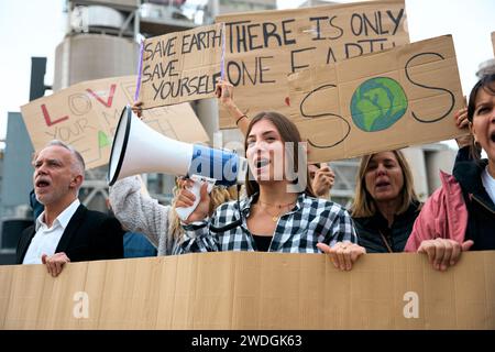 Femme criant avec un mégaphone dans une manifestation. Personnes à la manifestation sur le changement climatique Banque D'Images