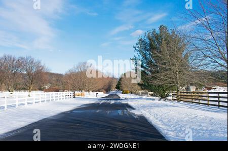 Route vide à Colts Neck, New Jersey, après quelques chutes de neige, sur un vif, ensoleillé, jour d'hiver -04 Banque D'Images