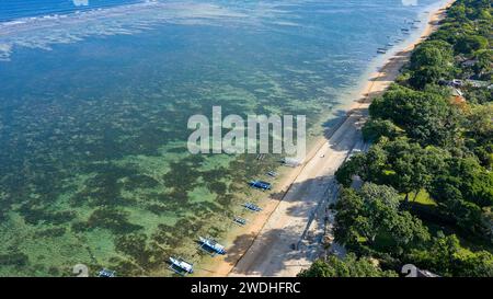 Vue aérienne d'une plage tropicale de sable entourée d'un feuillage luxuriant (Saur, Bali, Indonésie) Banque D'Images