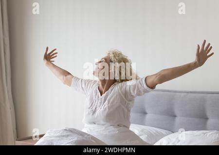 Femme souriante accueille une nouvelle journée heureuse se sentir rafraîchie après le sommeil Banque D'Images