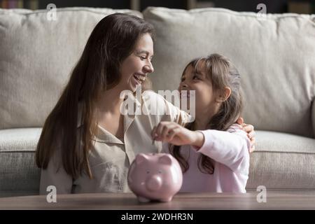 Petit enfant mit des pièces dans une tirelire Banque D'Images