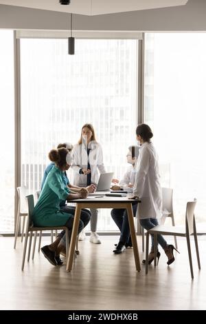 Jeune femme médecin en chef tenant une réunion avec une équipe médicale diversifiée Banque D'Images