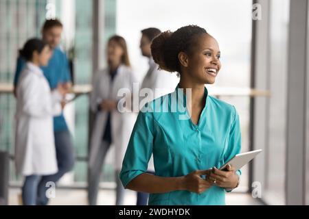 Positive rêveuse jeune femme médecin africaine debout pour la caméra Banque D'Images