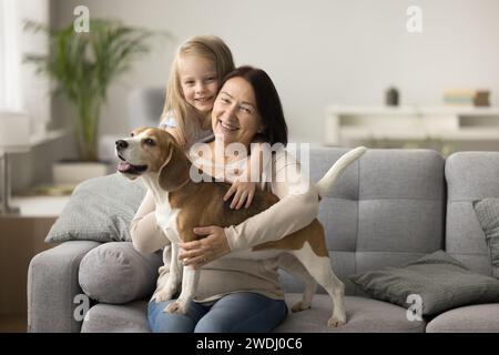 Joyeuse grand-mère et femme propriétaire de chien câlin beagle Banque D'Images