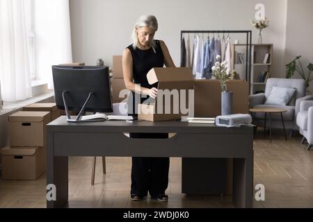 Femme d'affaires préparant la boîte, marchandises commandées au client pour l'envoi Banque D'Images