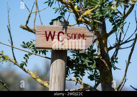 Flèche de panneau de toilette en bois, 500 mètres, sous un arbre, à l'intérieur du parc Aiguamolls Emporda, Catalogne, Espagne Banque D'Images