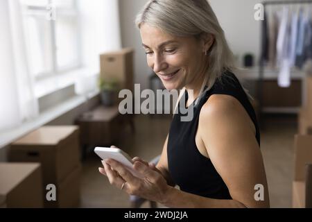 Femme appelant aux services de livraison, compagnie de transport le jour de la relocalisation Banque D'Images