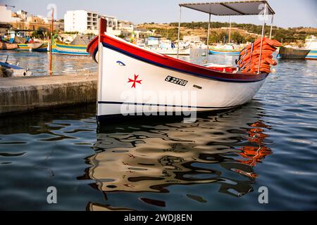 Marsaxlokk, Malte - 18 juin 2023 : bateau maltais typique, appelé luzzo, avec les yeux traditionnels et la croix maltaise dessinés sur la proue Banque D'Images