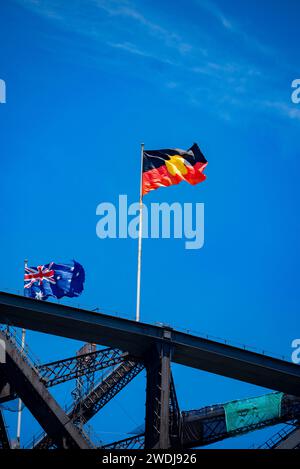 Le drapeau australien et le drapeau aborigène flottent ensemble au sommet du Sydney Harbour Bridge, en Nouvelle-Galles du Sud, en Australie, depuis juillet 2022 Banque D'Images