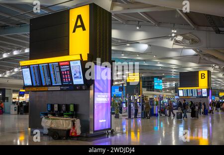 Panneaux d'information et marqueurs de zone dans la zone d'enregistrement dans le hall des départs du terminal cinq de l'aéroport d'Heathrow à Londres, Royaume-Uni. Banque D'Images