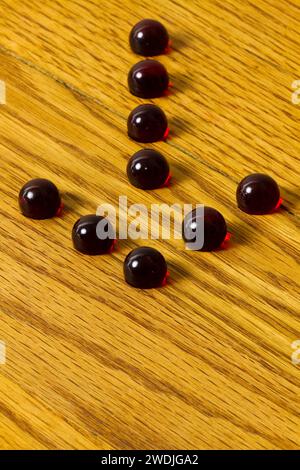 Un groupe de billes formant une flèche sur un plateau de jeu en bois. Banque D'Images