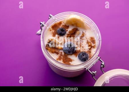 Photo de nourriture saine avec porridge, myrtilles, banane, cannelle et noix avec attrezo Banque D'Images