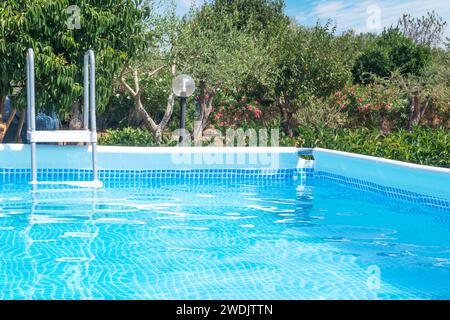 Piscine hors sol entourée de plantes vertes dans un jardin privé Banque D'Images