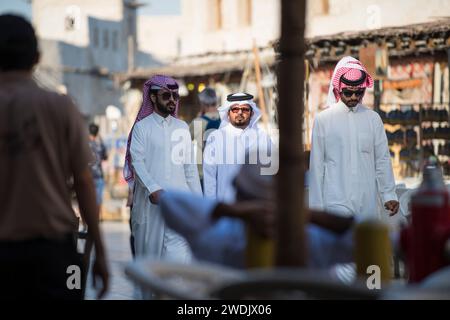 Doha, Qatar - 22 avril 2023 : les populations locales en tenue traditionnelle dans l'ancien marché du bazar Souk Waqif. Banque D'Images