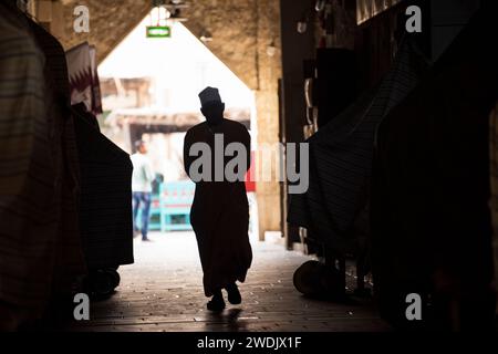 Doha, Qatar - 22 avril 2023 : les populations locales en tenue traditionnelle dans l'ancien marché du bazar Souk Waqif. Banque D'Images