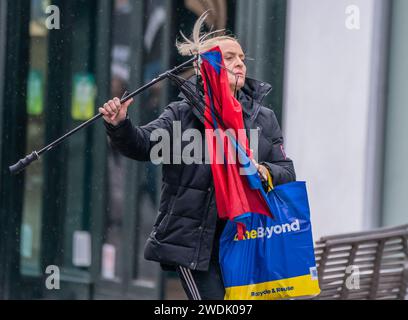 Une femme avec un parapluie cassé dans des conditions venteuses à Leeds. Le Royaume-Uni est couvert par des avertissements de vent « inhabituels » de danger pour la vie à l'approche de la tempête Isha, et les gens sont avertis de ne pas voyager en présence de rafales de 90 km/h. Date de la photo : dimanche 21 janvier 2024. Banque D'Images