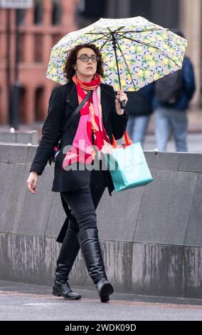 Une femme avec un parapluie à Leeds. Le Royaume-Uni est couvert par des avertissements de vent « inhabituels » de danger pour la vie à l'approche de la tempête Isha, et les gens sont avertis de ne pas voyager en présence de rafales de 90 km/h. Date de la photo : dimanche 21 janvier 2024. Banque D'Images