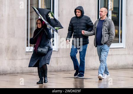 Une femme se bat avec un parapluie dans des conditions venteuses à Leeds. Le Royaume-Uni est couvert par des avertissements de vent « inhabituels » de danger pour la vie à l'approche de la tempête Isha, et les gens sont avertis de ne pas voyager en présence de rafales de 90 km/h. Date de la photo : dimanche 21 janvier 2024. Banque D'Images