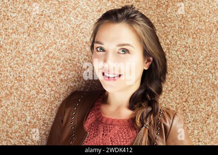 Gros plan portrait de belle jeune femme de 25-30 ans avec maquillage professionnel, portant une veste en cuir marron Banque D'Images