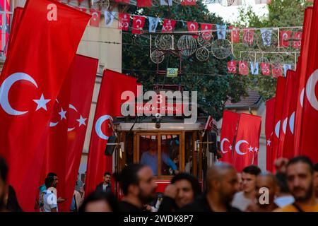 Vue sur l'avenue Istiklal avec les gens et les drapeaux turcs. Istanbul Turkiye - 10.28.2023 Banque D'Images