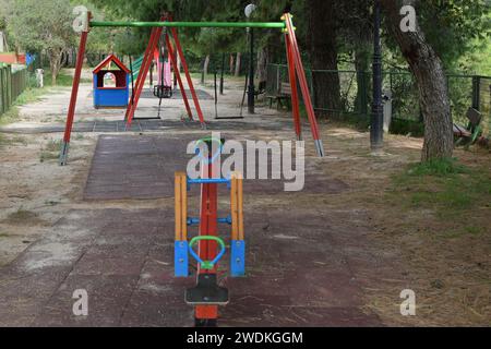 Balançoires et bancs assis dans le parc de jeux public. Banque D'Images