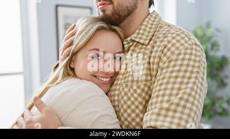 Un couple amoureux embrasse chaleureusement dans leur salon confortable, mettant en valeur l'affection et une relation forte. Banque D'Images