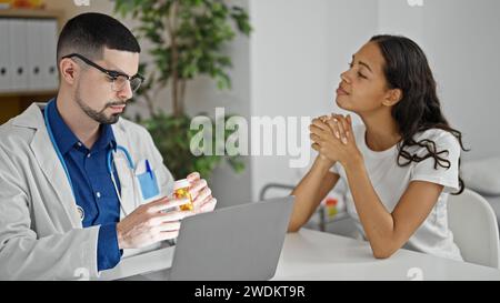 À l’intérieur de la clinique, un médecin compatissant prescrivant des pilules pendant la consultation, tandis qu’un patient détendu écoute attentivement Banque D'Images
