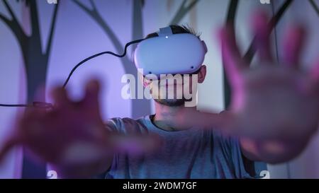 Deux jeunes hommes, visiteurs de musée d'histoire naturelle, utilisant les nouvelles technologies dans l'exposition, mettant des casques de réalité virtuelle. Banque D'Images