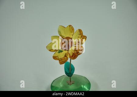 tournesol en verre se balançant d'avant en arrière sur une tige en métal argenté. Blossom présente 5 pétales de cristal de topaze jaune clair à facettes et un cristal de cuivre à facettes Banque D'Images