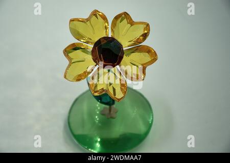 tournesol en verre se balançant d'avant en arrière sur une tige en métal argenté. Blossom présente 5 pétales de cristal de topaze jaune clair à facettes et un cristal de cuivre à facettes Banque D'Images