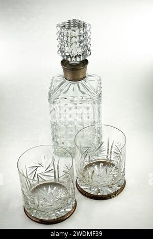 Carafe en cristal taillée et deux verres sculptés avec décoration argentée sur le bouchon et sur le bord des verres Banque D'Images