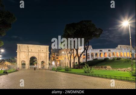 Paysage urbain nocturne de Rome : vue du Colisée et de l'Arc de Constantin, Italie. Banque D'Images